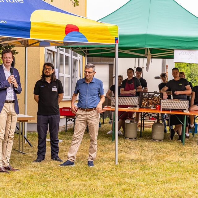 Gäste und Vereinsmitglieder versammeln sich für den offiziellen Teil im Außenbereich.