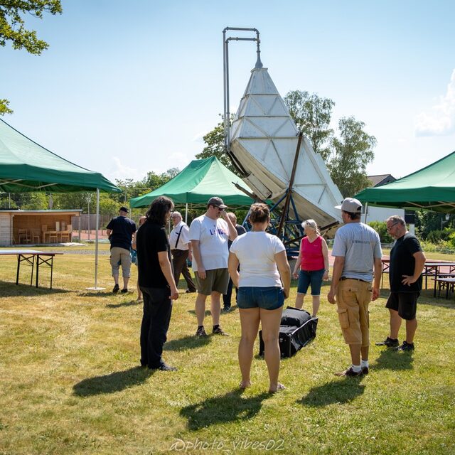 Gäste bewegen sich zwischen Pavillons und Radioteleskop.