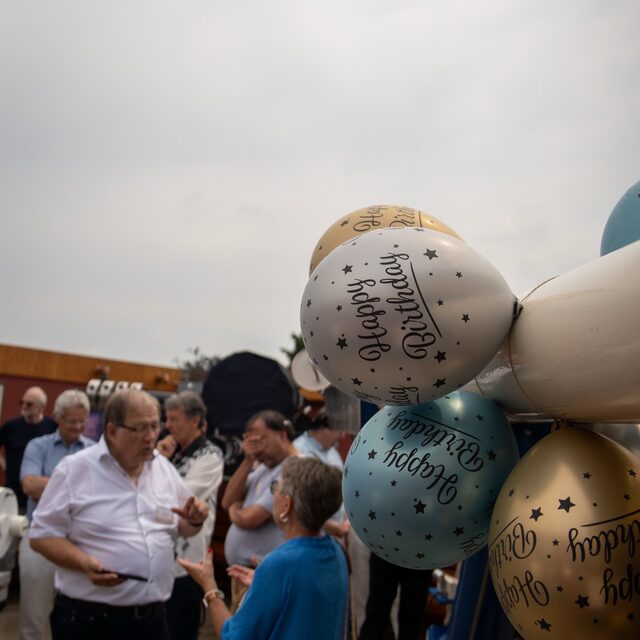 Eine Besuchergruppe steht rund um den geschmückten Refraktor.