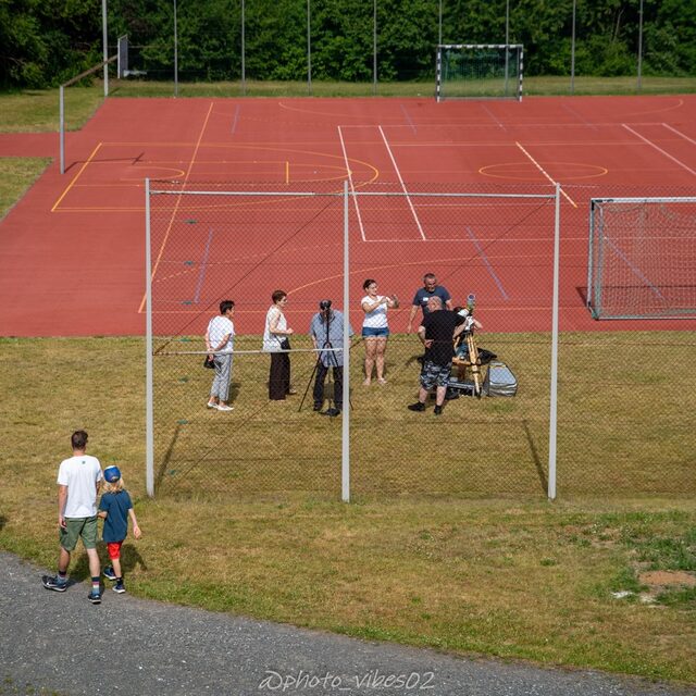 Von erhöhter Position sieht man Gäste und Teleskopstationen am Sportplatz.