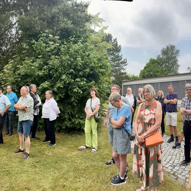 Die Besuchergruppe bewegt sich zwischen Eingang und Außenbereich.