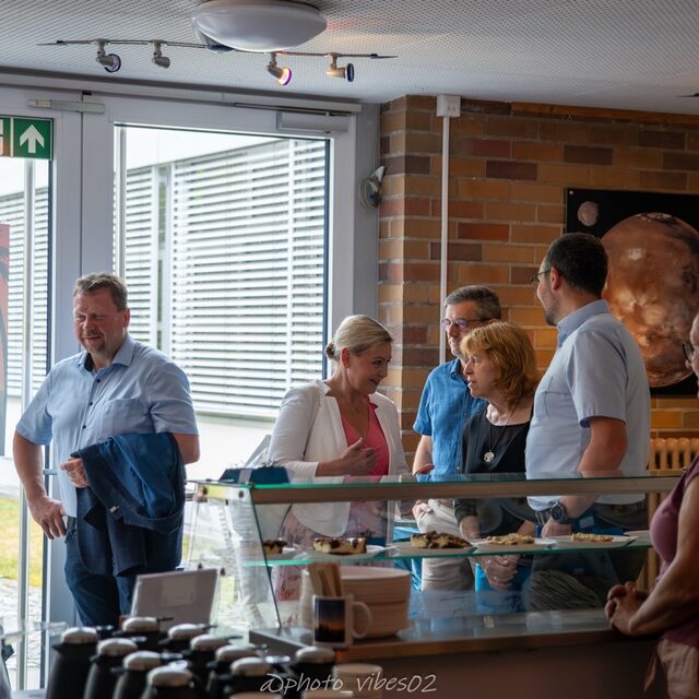 Ehrengäste stehen im Foyer am Buffet.