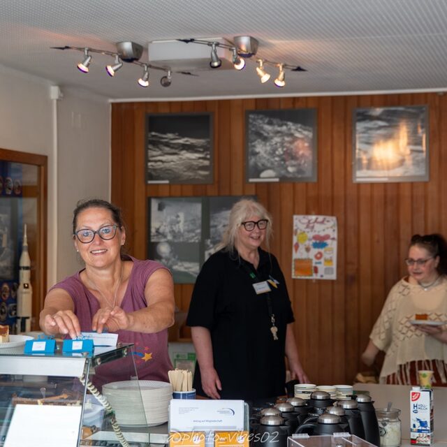 Helferinnen betreuen den Empfangsbereich mit Kaffee und Kuchen.
